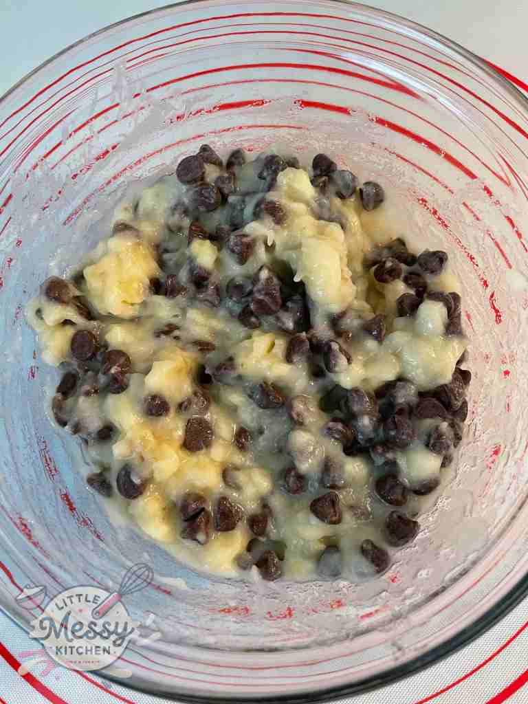 Mashed banana and chocolate chips mixed in a bowl.