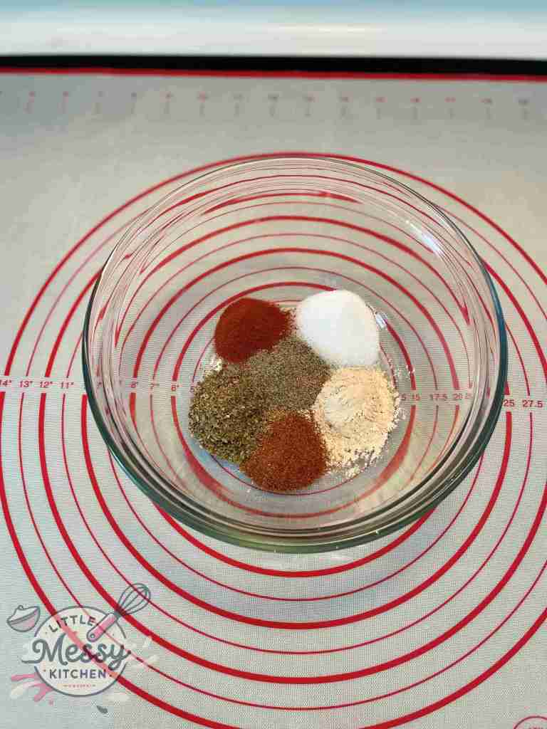 Bowl with salt, garlic powder, chili powder, oregano, paprika, and pepper.