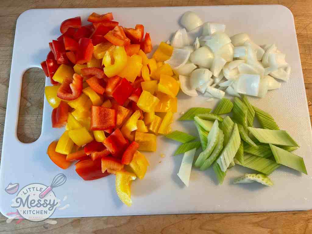 Diced peppers, celery, and onions on a cutting board.