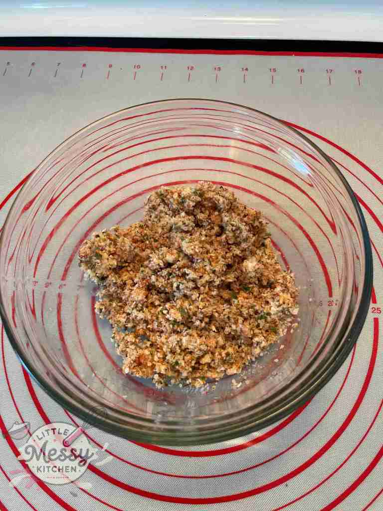 Minced onion and garlic, parsley, and Italian breadcrumbs mixed in a bowl.