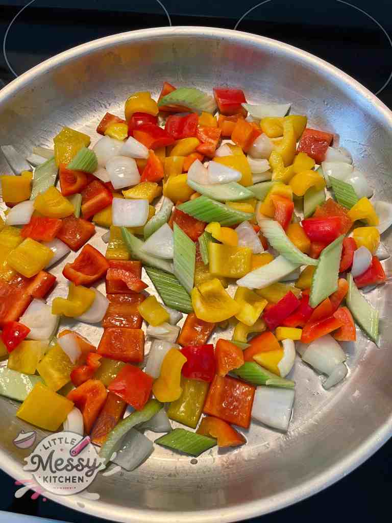 Diced peppers, celery, and onions on a cutting board.