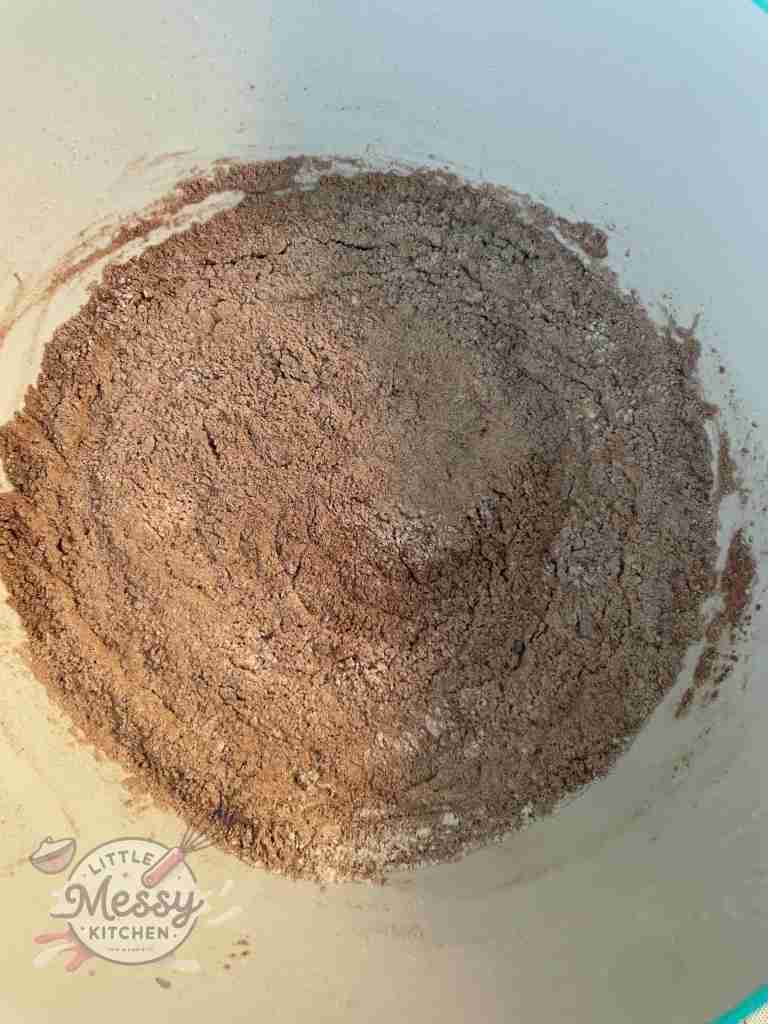 Flour, cocoa powder, baking powder, and baking soda combined in a bowl.