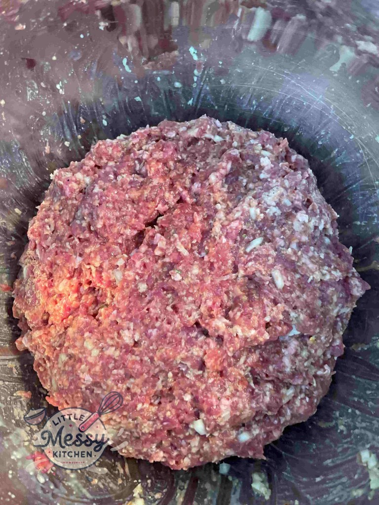 Breadcrumb mixture combined with ground beef and pork, fully mixed.
