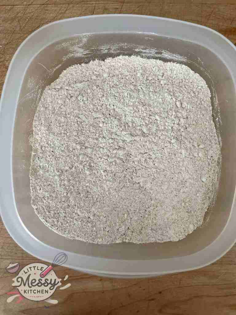 Flour, coriander, paprika, cumin, salt and pepper mixed in a bowl.