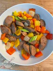 Dish of peppers, celery, onions and sausages and a serving bowl.