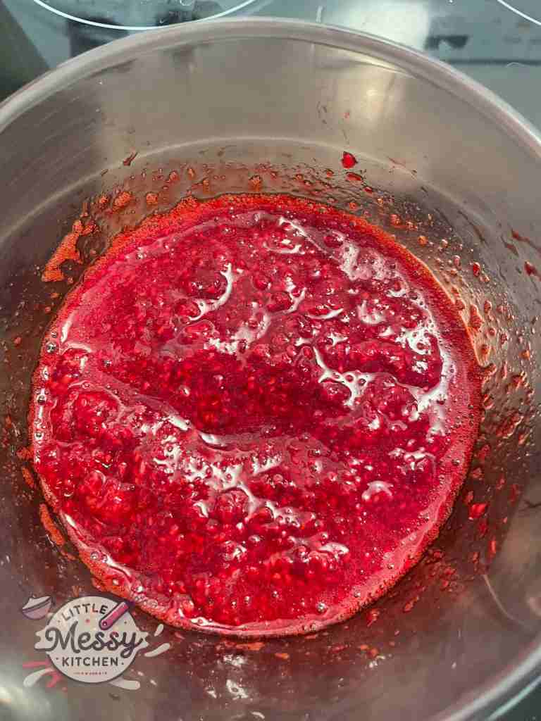 mashed raspberries in a saucepan.