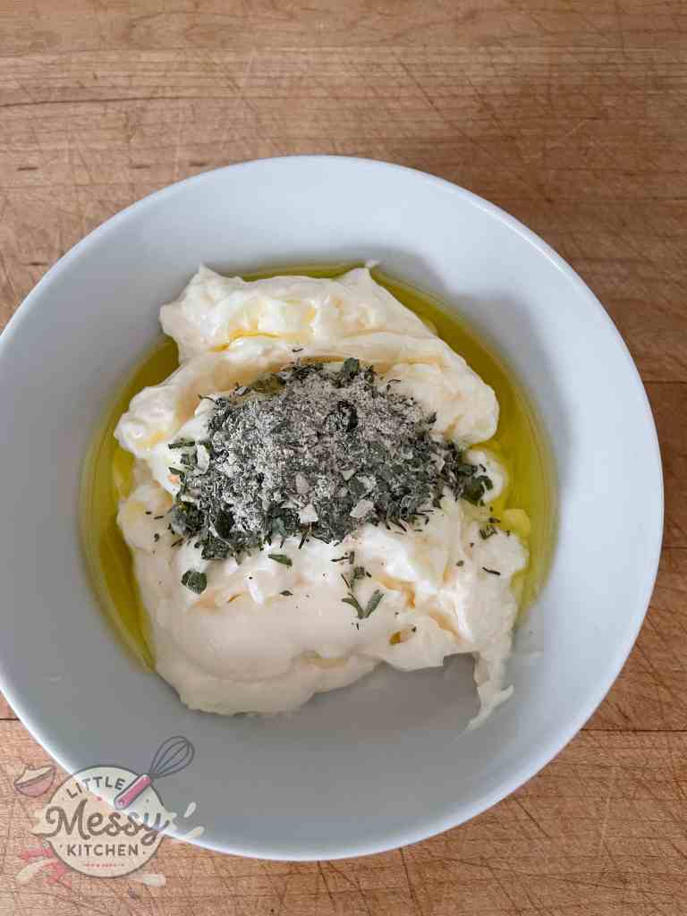 Mayonnaise, olive oil, and ranch spice mix in a mixing bowl, ready to be combined.