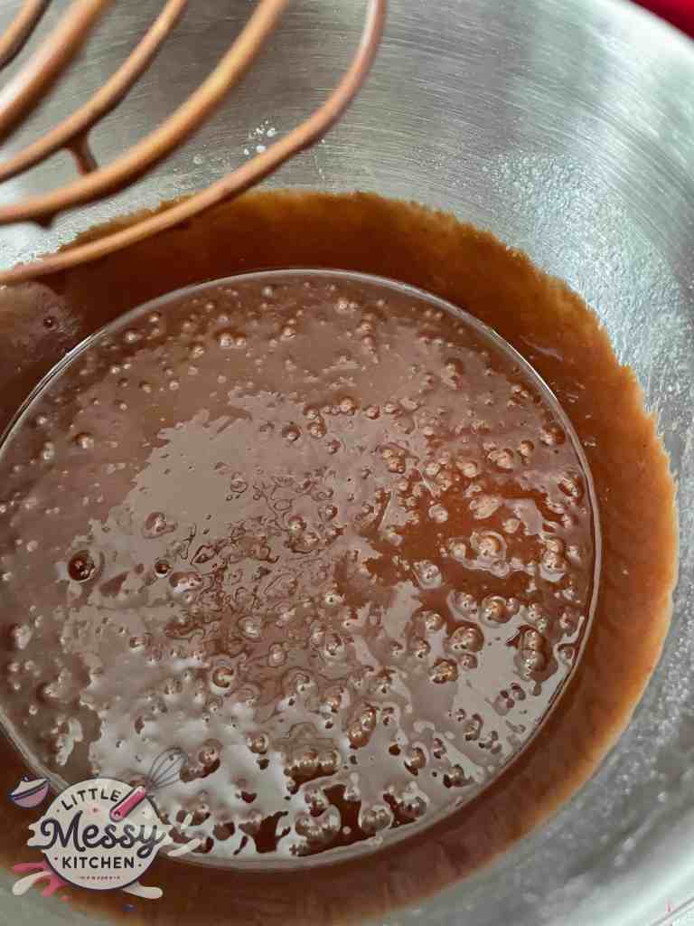 Flour mixture and chocolate mixture combine in a bowl ready to be poured in muffin pan.