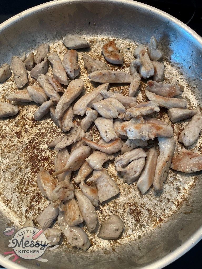 Chicken slices cooked in skillet.