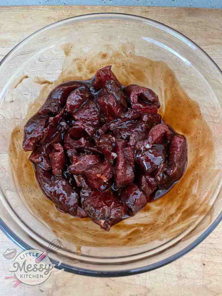 Steak cubes marinating in a bowl.