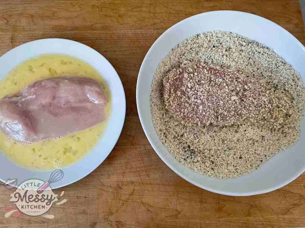 Chicken breast at a breading station.