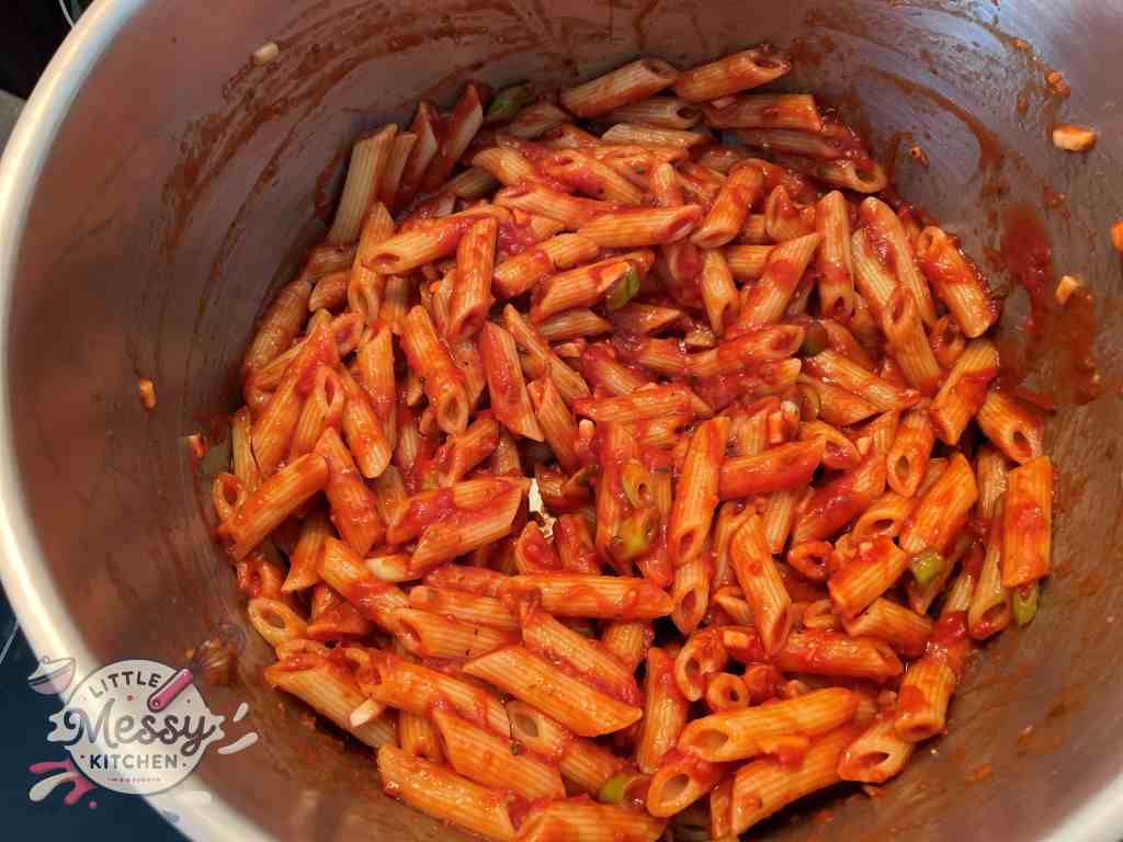 Cooked pasta mixed with sauce in a pot.