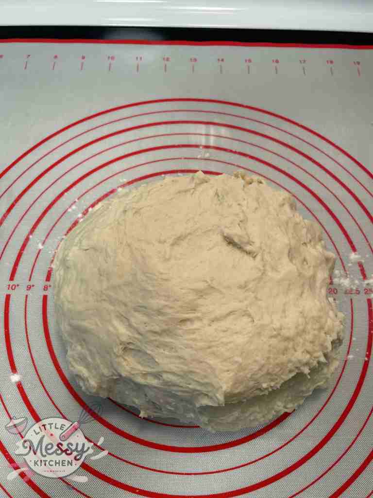 Slightly sticky bread dough on a pastry mat.