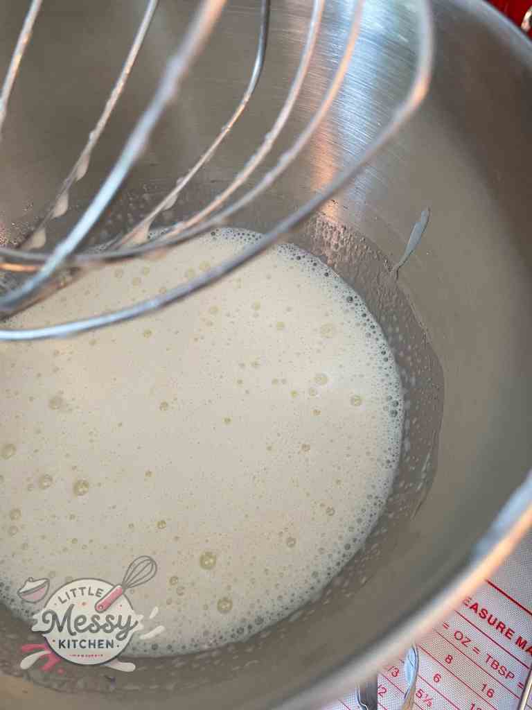 Milk and butter mixture added to eggs in a stand mixer.