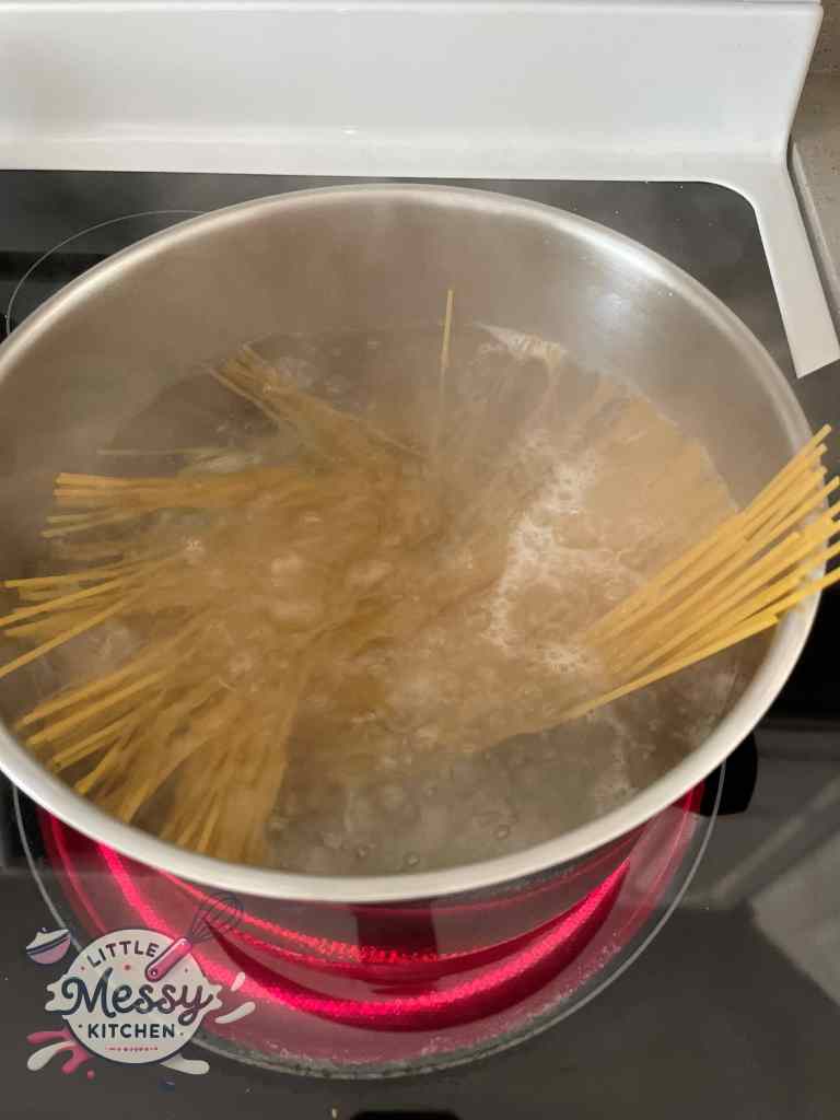 Spaghetti in a boiling pot of water.