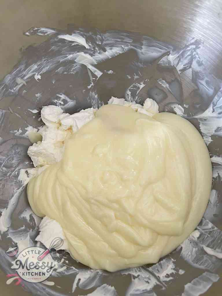 Cream cheese and vanilla pudding in mixing bowl ready to be combined.