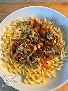 Beef & cabbage stir fry served on a bed on noodles