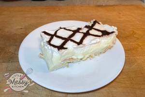 Slice of cream puff cake served in a white plate.