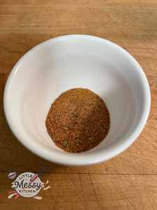 Presented spices: cayenne pepper, chili powder, ground cumin, onion powder, oregano, and roasted garlic, mixed in a bowl.