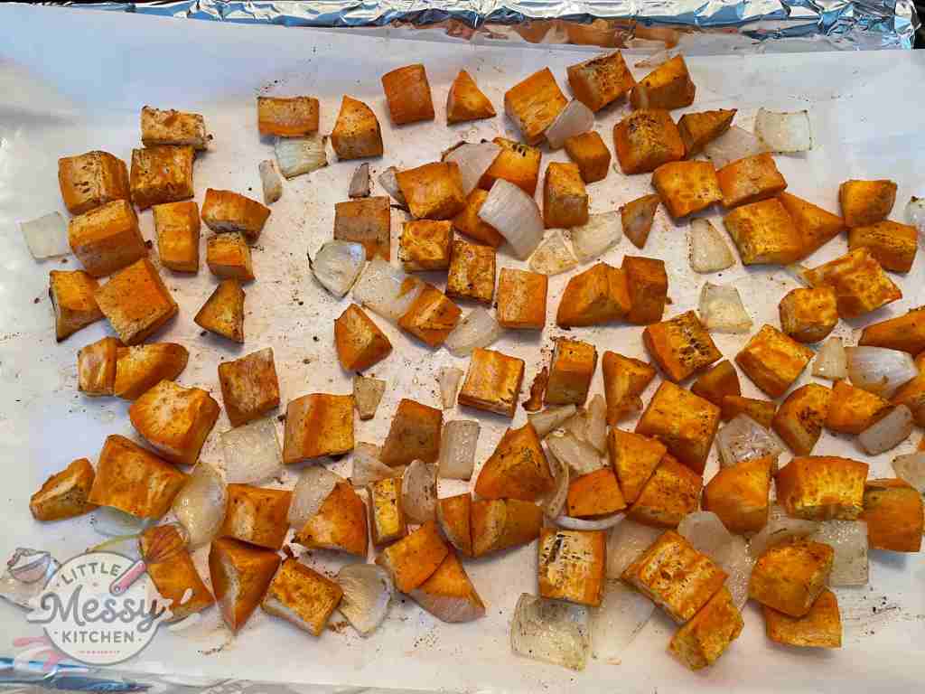 Sweet Potato and onions on a baking sheet.