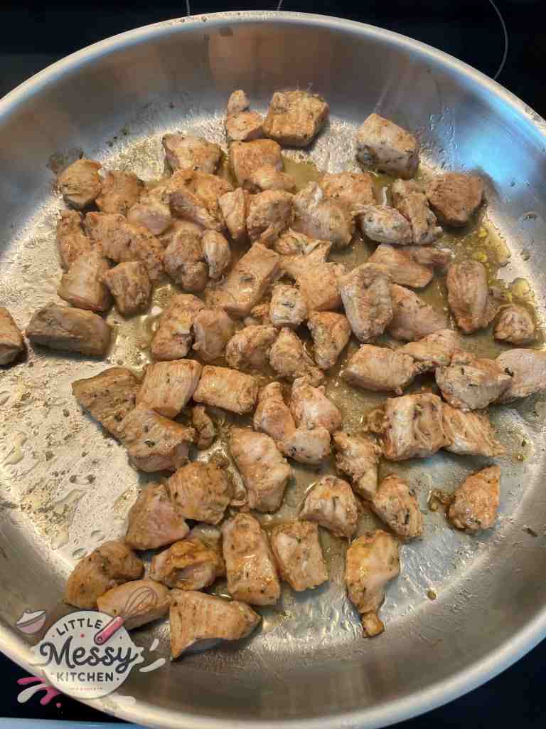 Seasoned Chicken Cooking in Skillet.