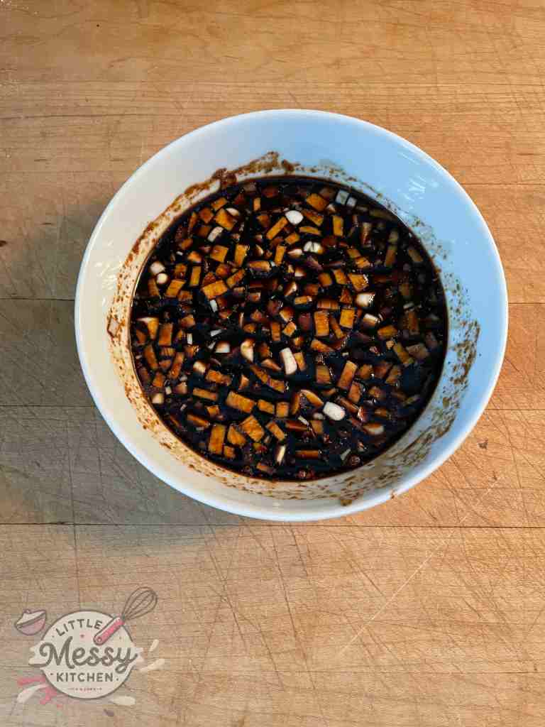 Soy sauce, garlic, ginger, brown sugar and white pepper mixed in a bowl.