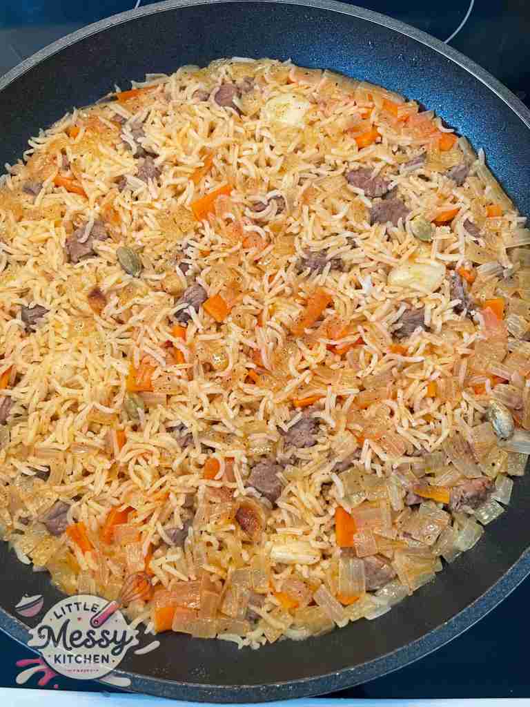 Cooked beef and rice plov style in skillet.