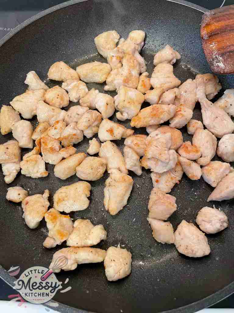 Chicken cubes cooked golden brown in a skillet.