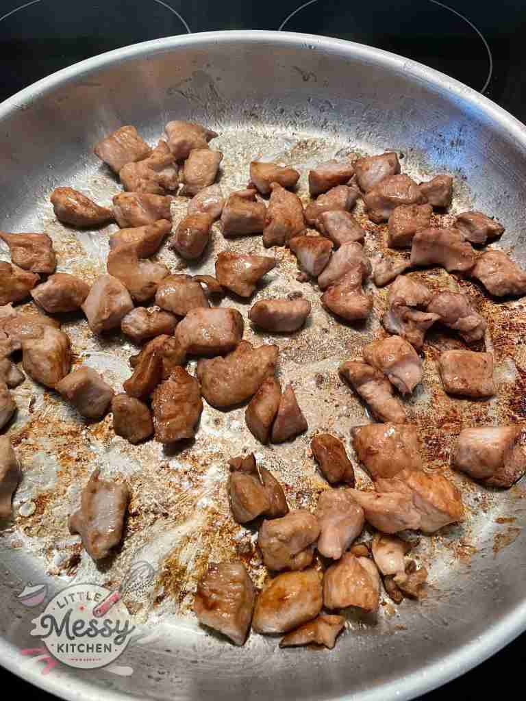 Marinated chicken in a frying pan.