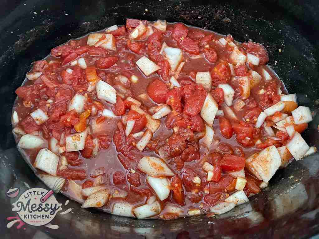 Tomatoes, onions, garlic and spices in a slow cooker.