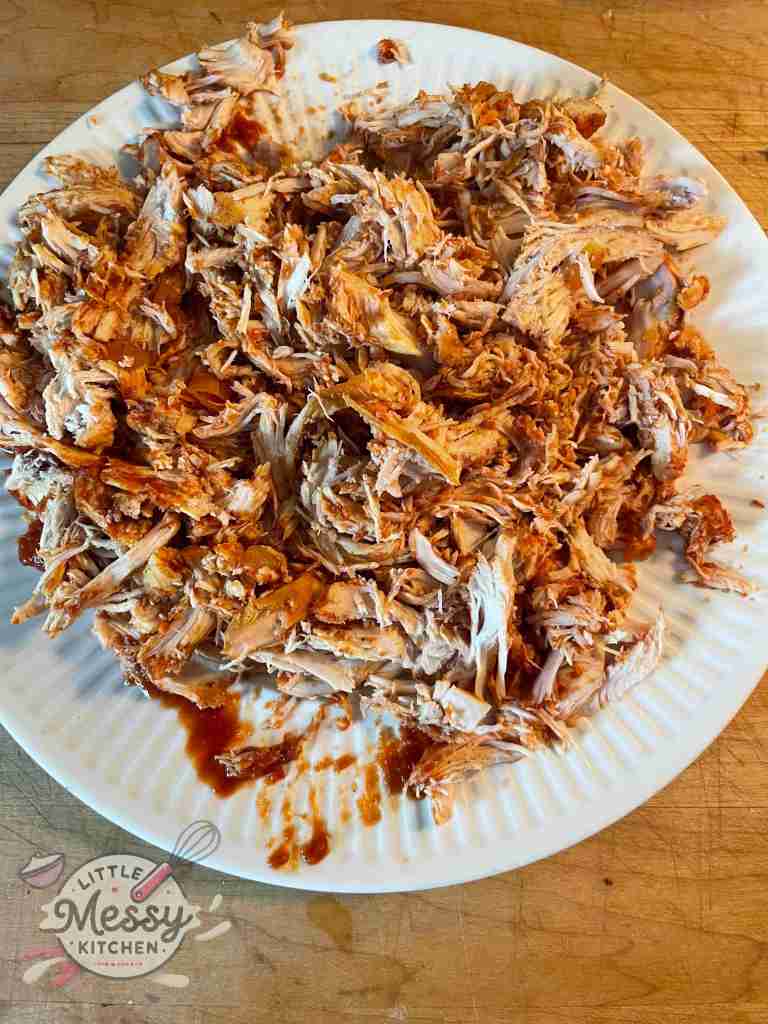 Cooked chicken shredded on a plate.