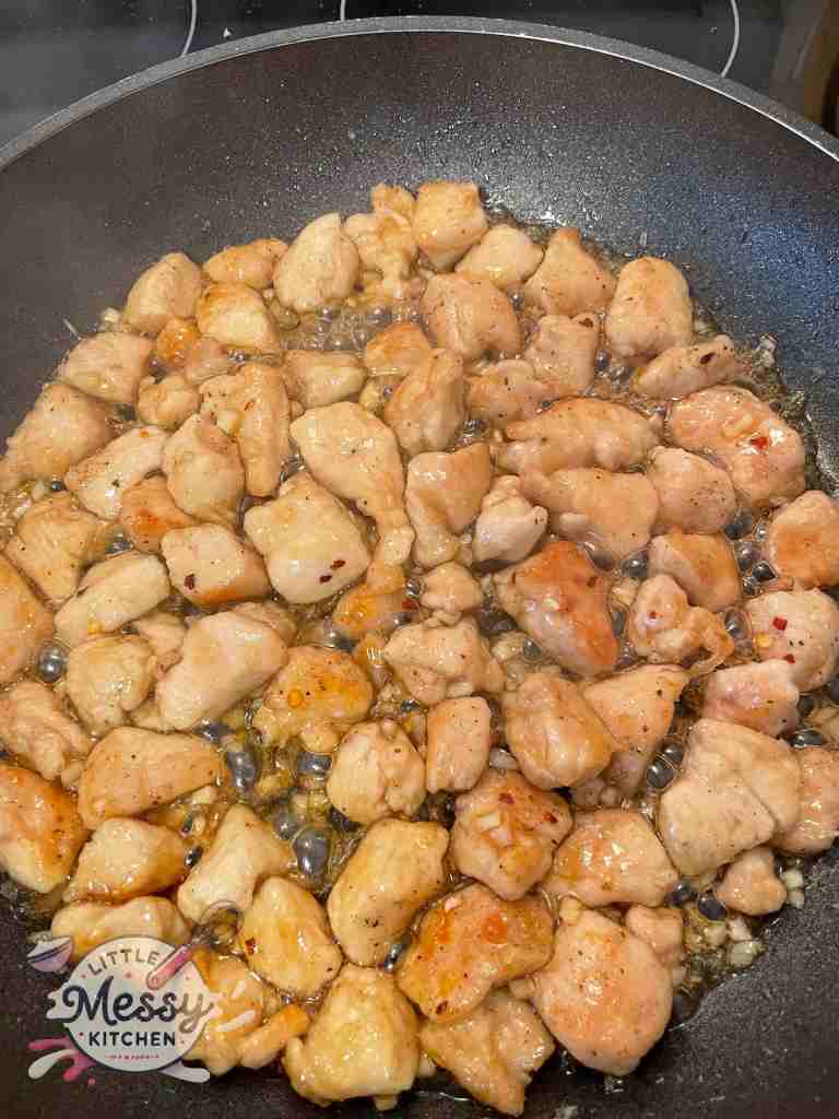 Sauce ingredients added to the chicken in the skillet.