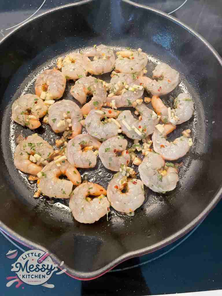 Shrimp cooking in cast iron skillet.
