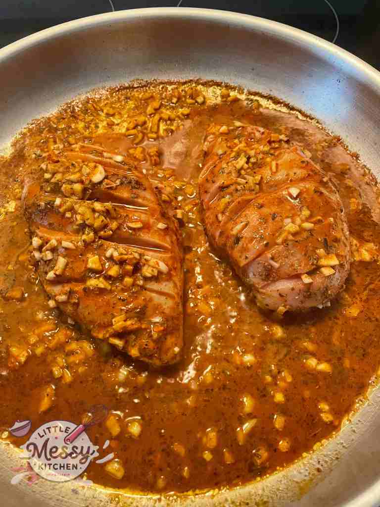 Marinated chicken cooking in skillet. 