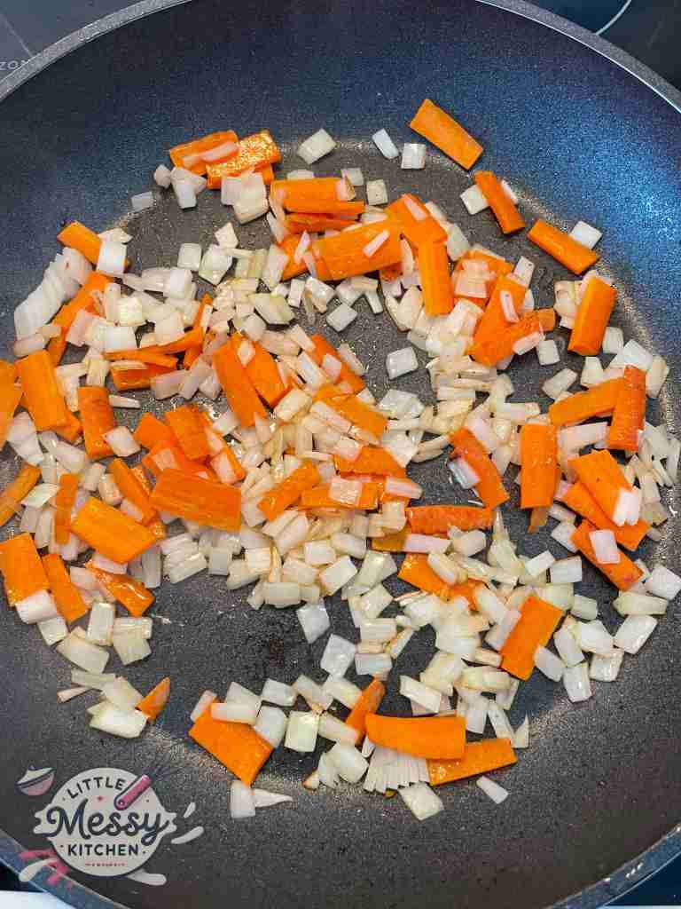 Carrots and onions, sauteing in a skillet.