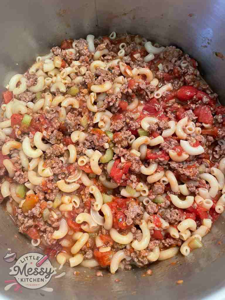Ground beef mixture, diced tomatoes and macaroni in a stockpot.