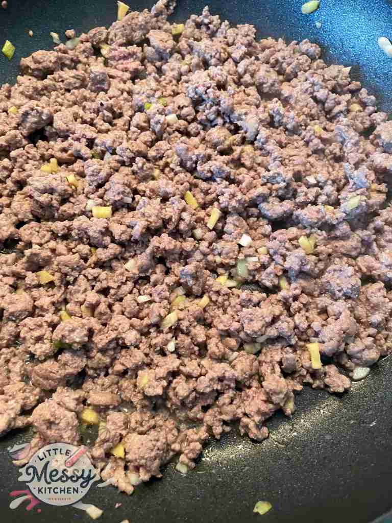 Ground beef, garlic and ginger cooking in a skillet.