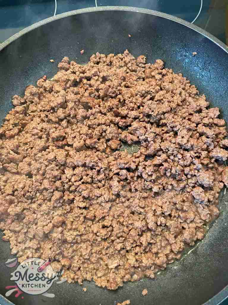 Ground beef cooking in a skillet.