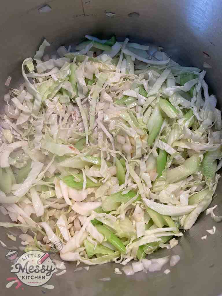 Onion, celery and cabbage sauteing in a stockpot.