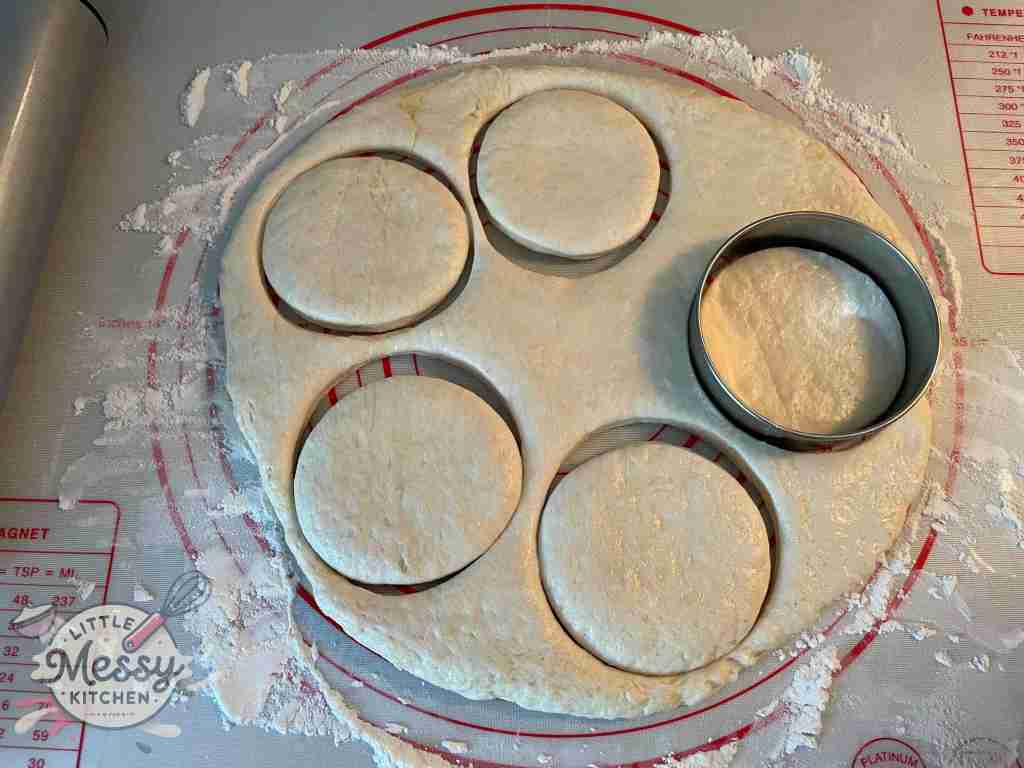 Dough rolled on a pastry mat cut with a cookie cutter