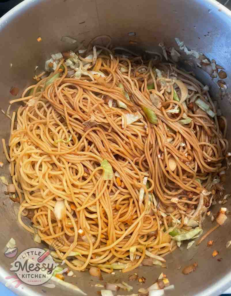 Spaghetti and soy sauce mixture added to the veggies in stockpot.