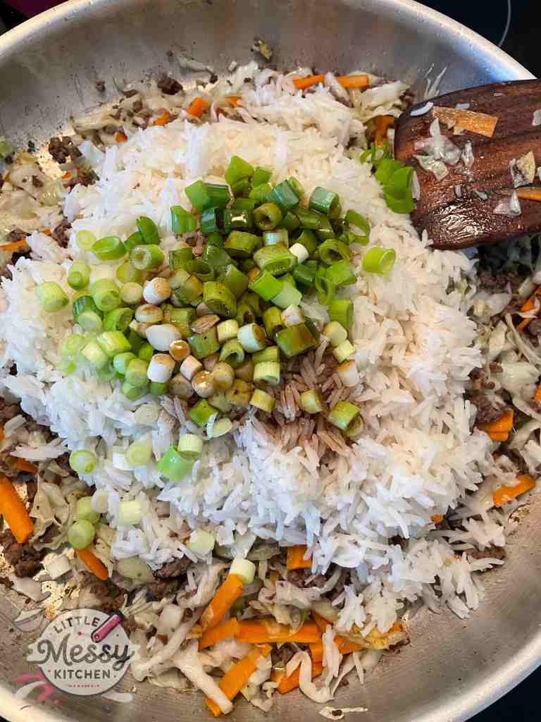 Rice and green onions added to the frying pan.