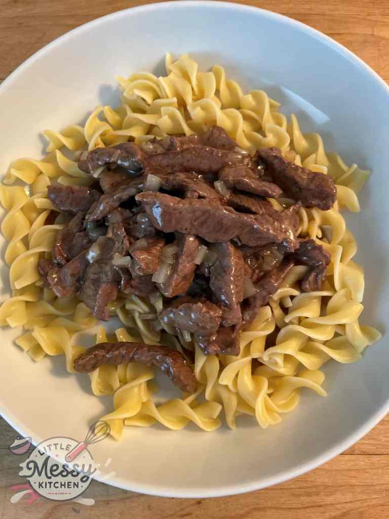 Serving of beef and noodles in a white bowl.