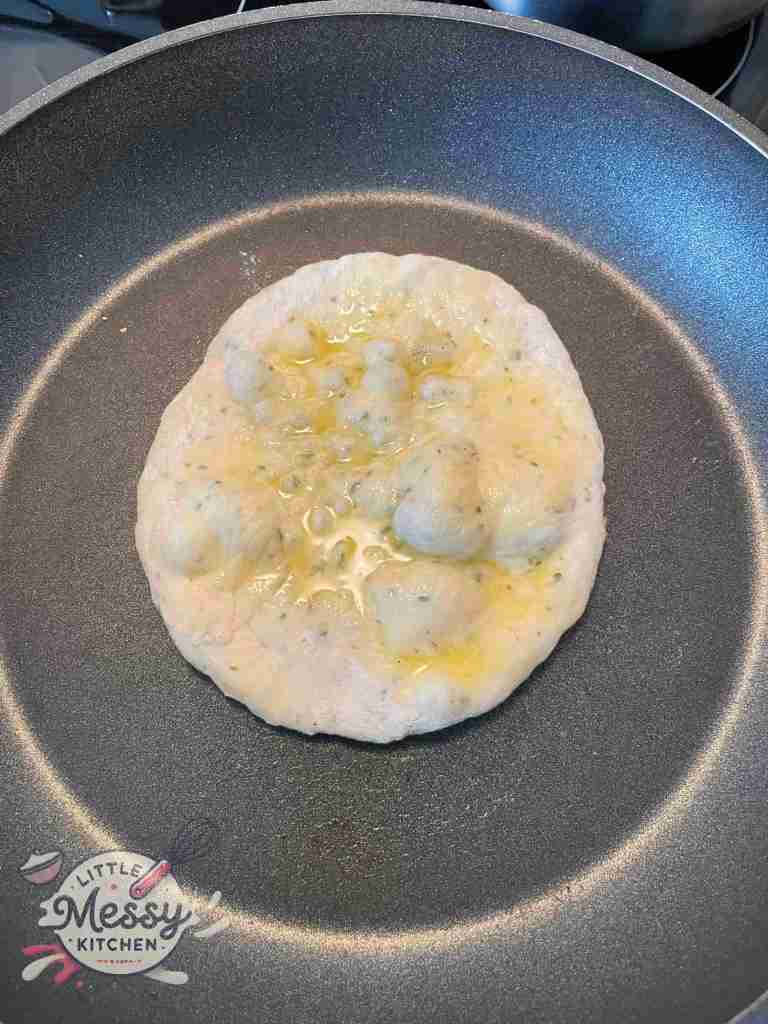 Flatbread cooking in frying pan.