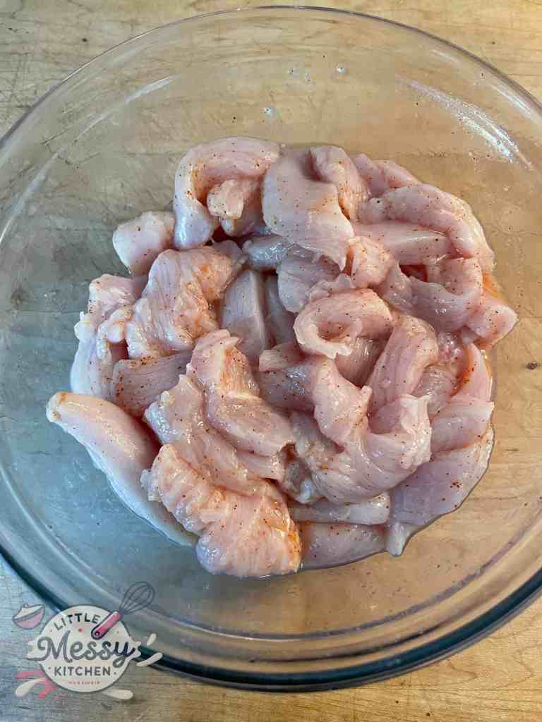 Chicken marinating in a bowl.