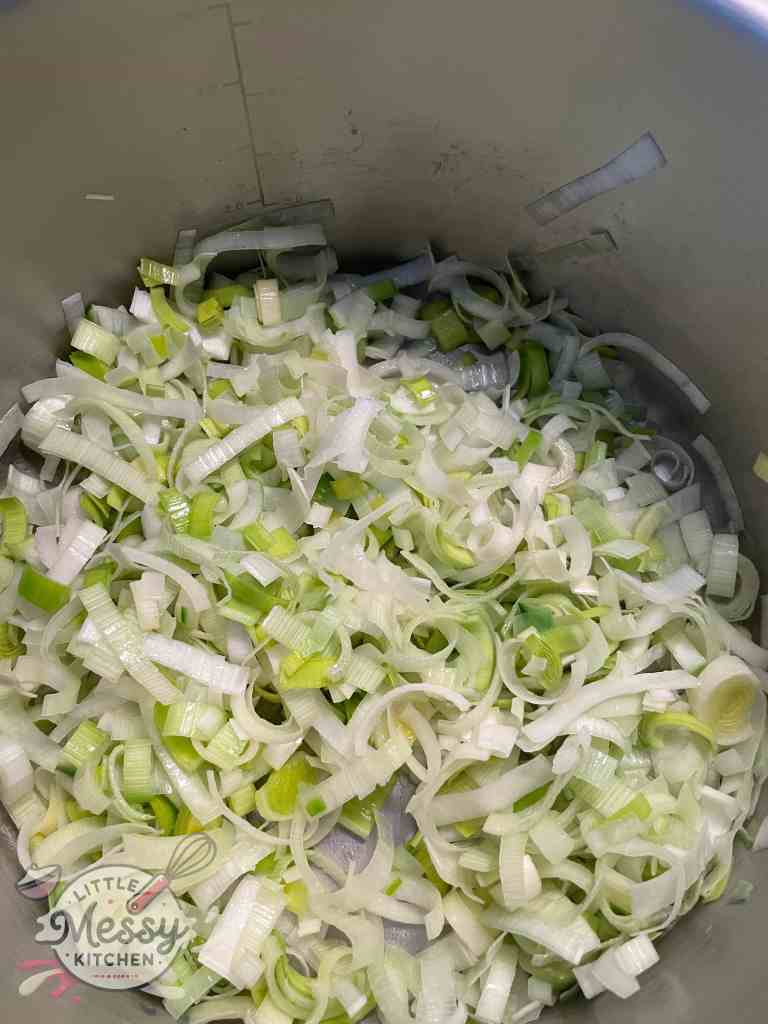 Sliced leeks cooking in a stockpot.