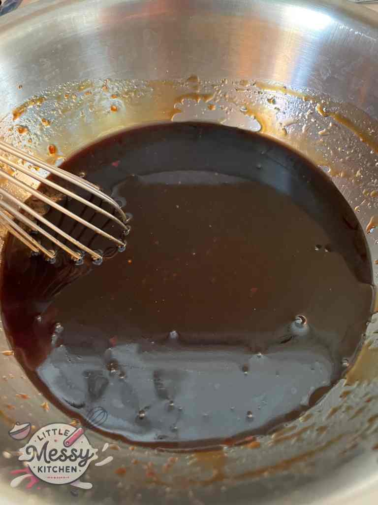 Sauce ingredients; Honey, ketchup, sugar, brown sugar, white vinegar, soy sauce, toasted sesame oil, salt, and garlic powder mixed in a mixing bowl.