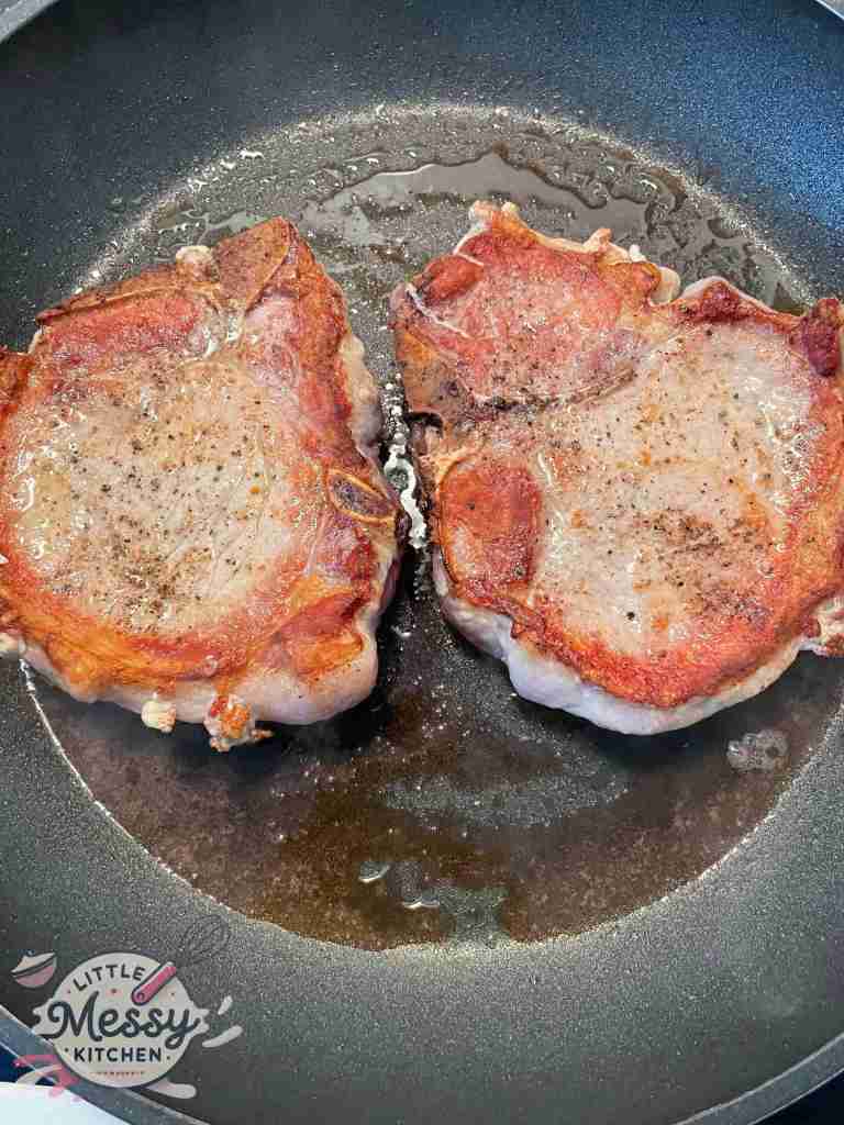 Pork chops Searing in skillet.