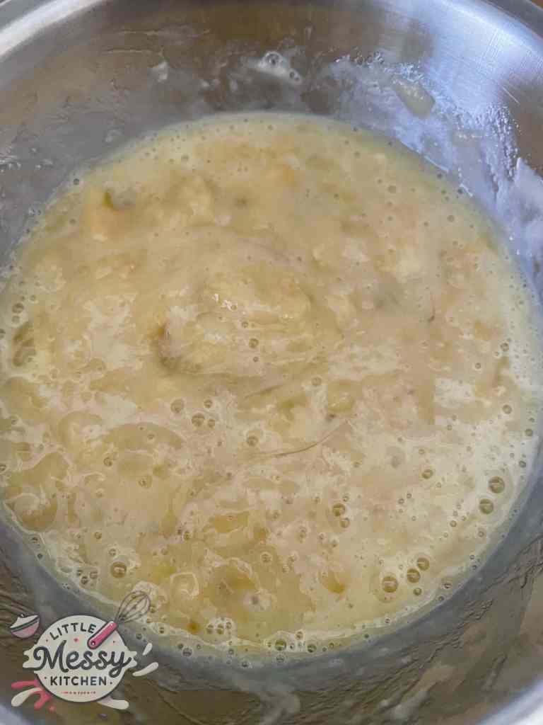 Banana, egg and vanilla extract mixed in a bowl.