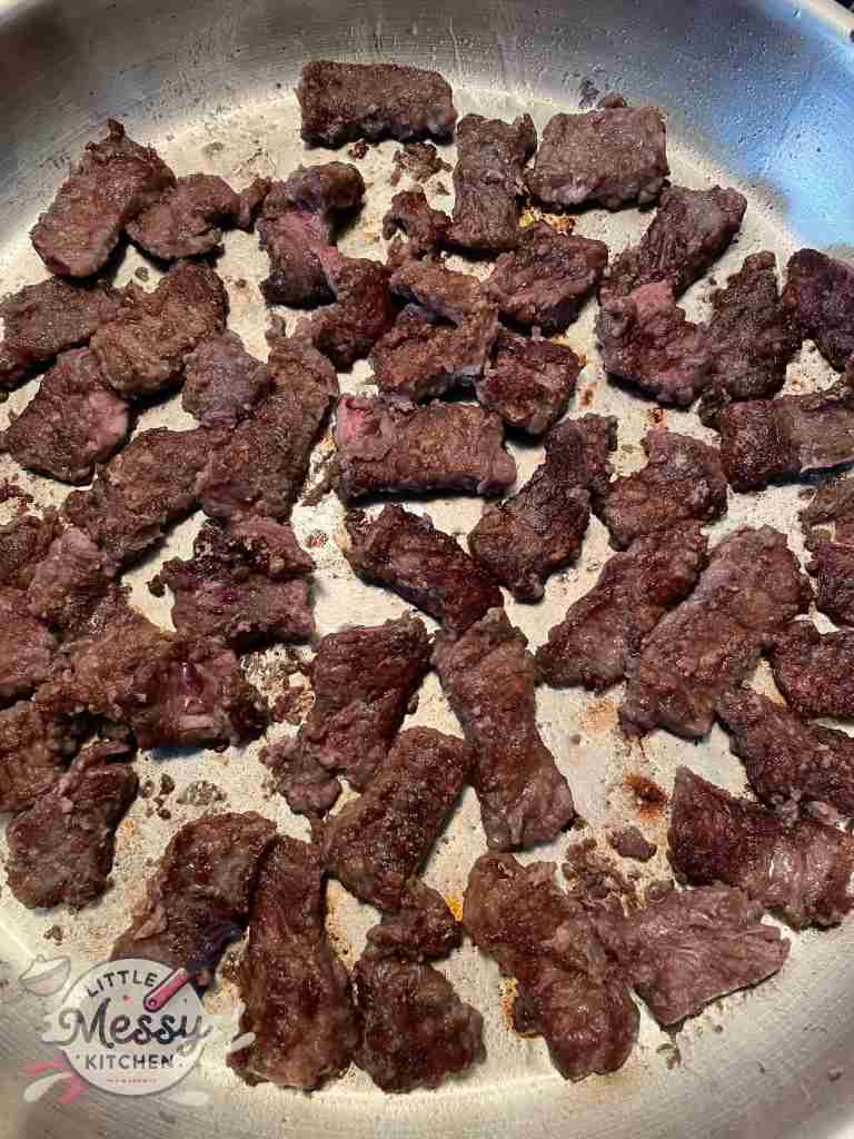 Golden brown beef in frying pan.